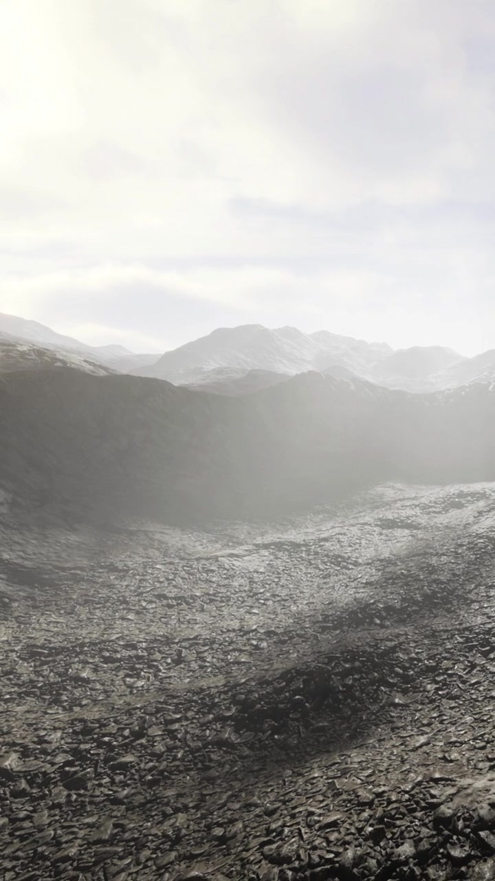 Misty landscape with rocky terrain and distant mountains during daytime