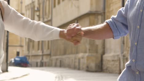 sección media de una pareja de turistas juguetones divirtiéndose en la calle