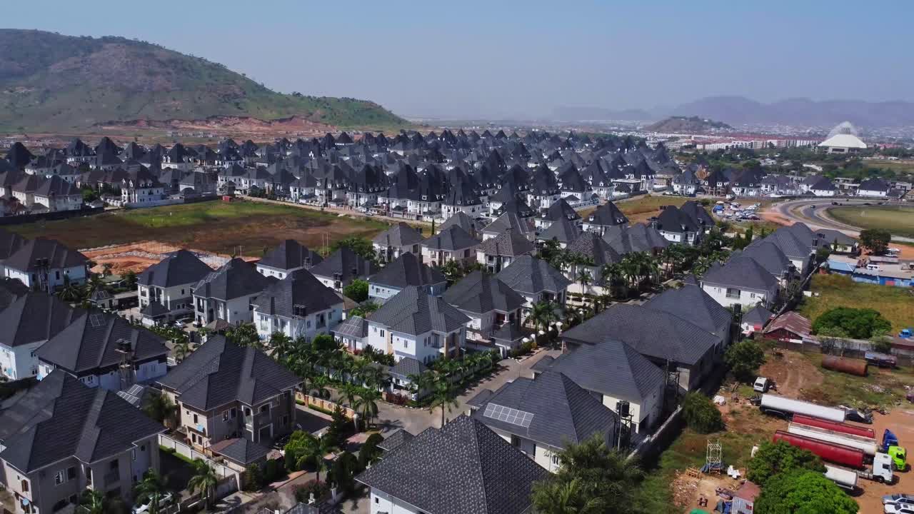 Cảnh quay trên không đẹp mắt về những ngôi nhà sang trọng trong khu dân cư ngoại ô mới xây ở Abuja, Nigeria. Máy bay không người lái bay lùi phía trên những ngôi nhà có tấm pin mặt trời quang điện trên mái nhà