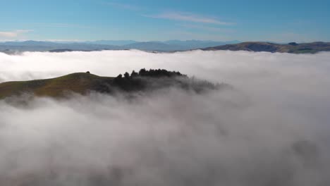 beautiful dreamlike view of a hilltop above a sea of fog and mist