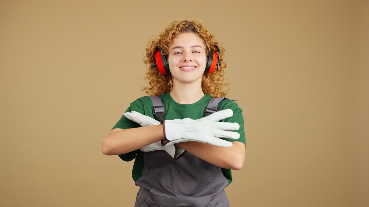 Smiling Woman in Work Overalls and Ear Protection