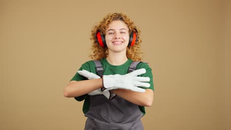 smiling woman in work overalls and ear protection