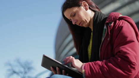 slow motion shot of serious woman using tablet outdoor