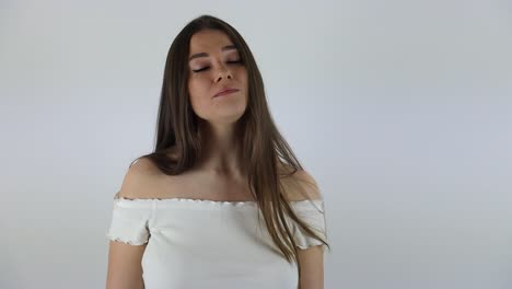 clip en cámara lenta de una joven atractiva cantando frente a un fondo blanco