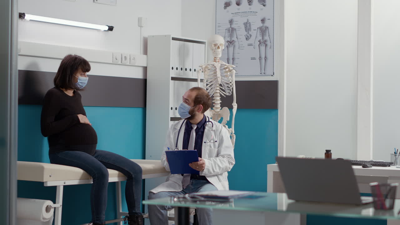 Obstetra consultando gestante usando máscara de proteção