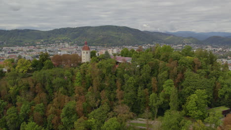 vista aérea volando lejos del parque arbolado schloßberg hilltop de graz y la torre glockenturm