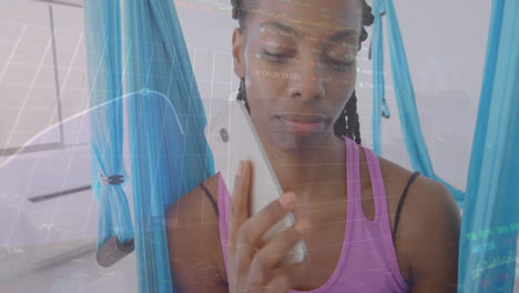 animation of multiple graphs and trading boards, african american woman making call using cellphone