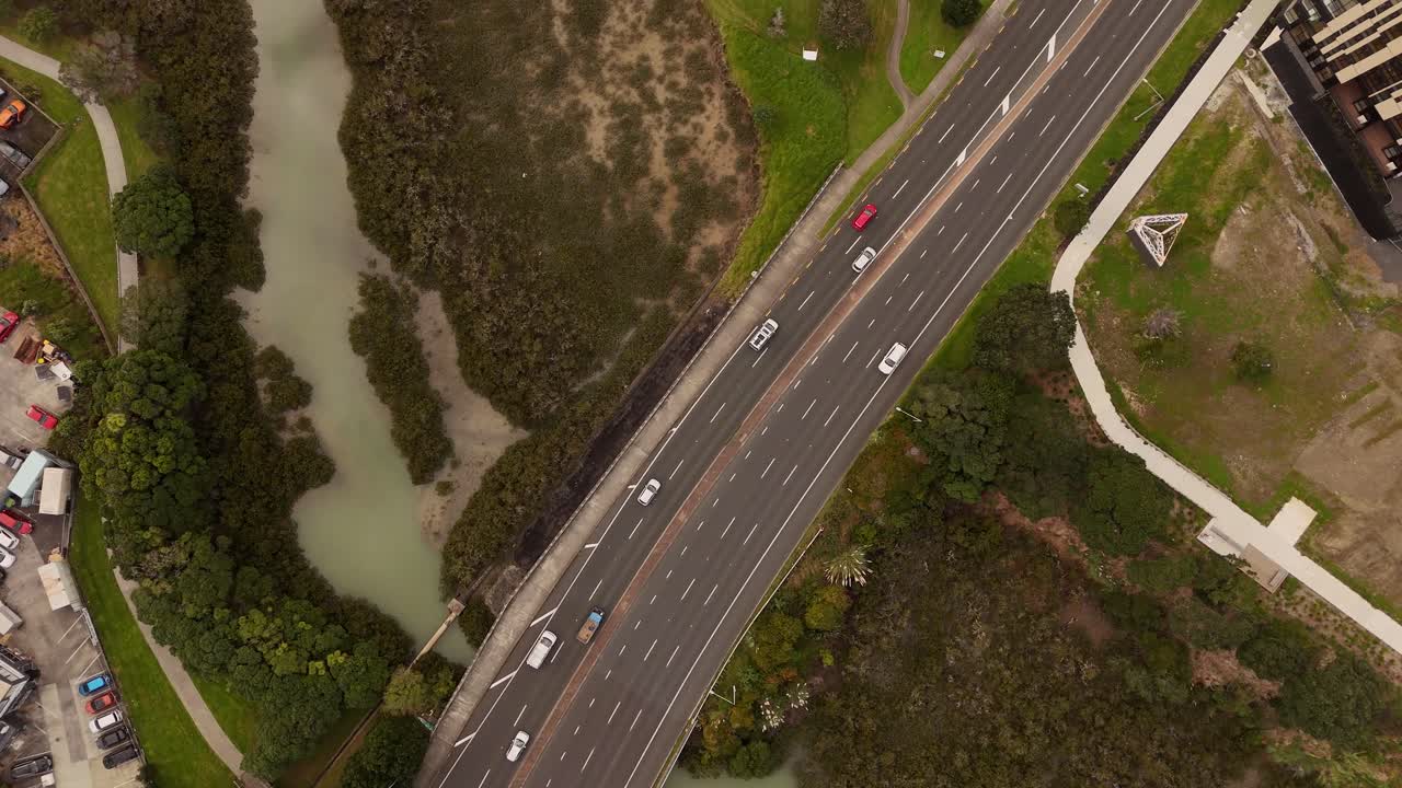 A 4K 60fps top-down bird's-eye view of busy traffic on Auckland's Northern Motorway. This unique perspective shows the graphic patterns and constant flow of the daily commute and city infrastructure