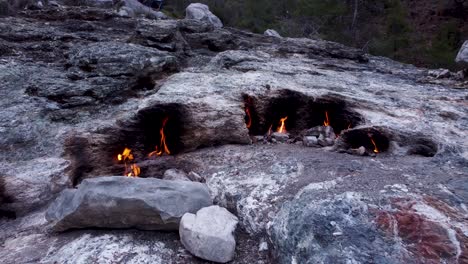 eternal flames: natural gas fireplace burning out of stone rocks at mount chimaera, turkey