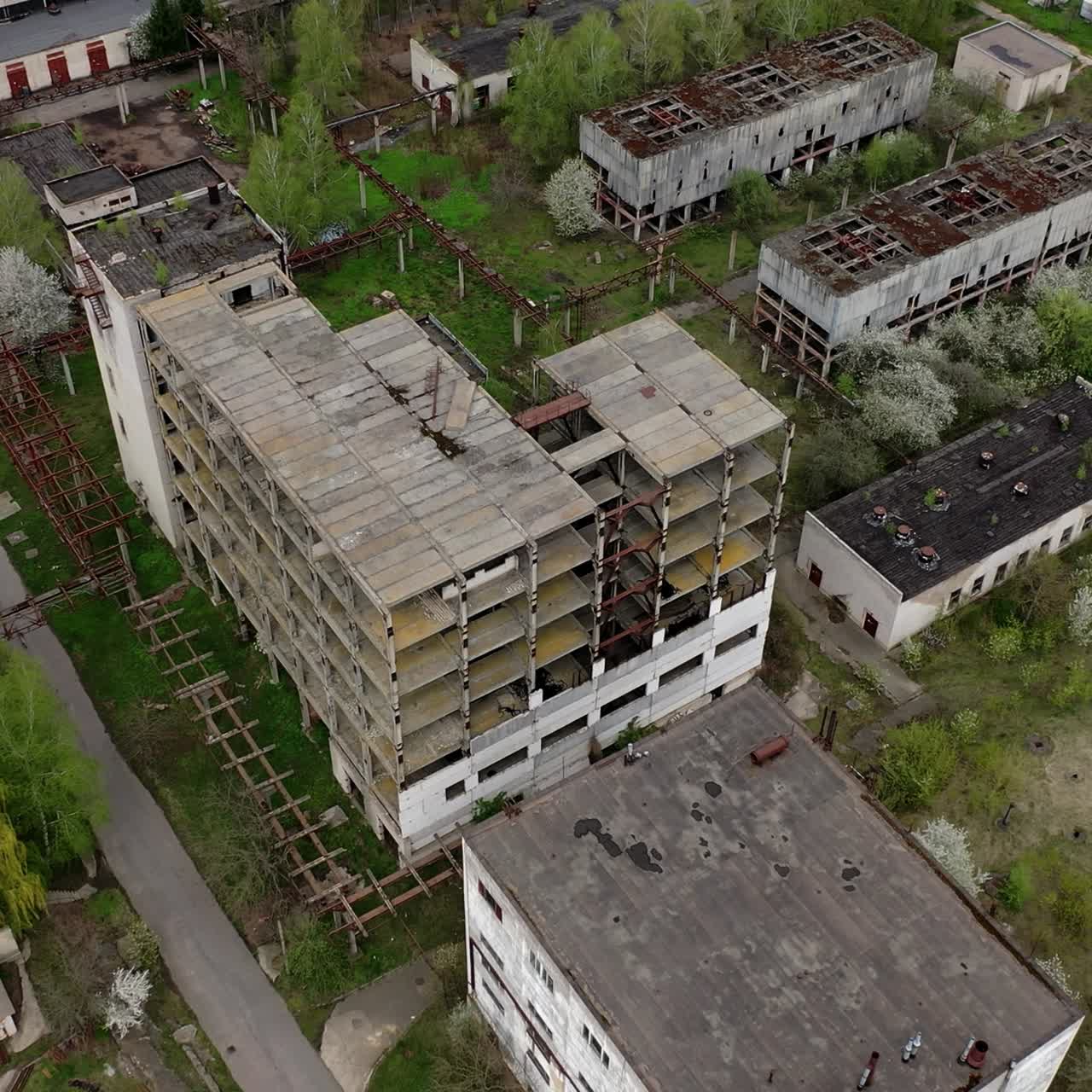 Ruined factory buildings. Abandoned warehouses or production department on the factory territory. Old industrial edifices for demolition. Aerial view