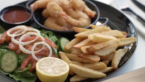 enjoying a delicious seafood platter at a cozy seaside restaurant during a sunny afternoon
