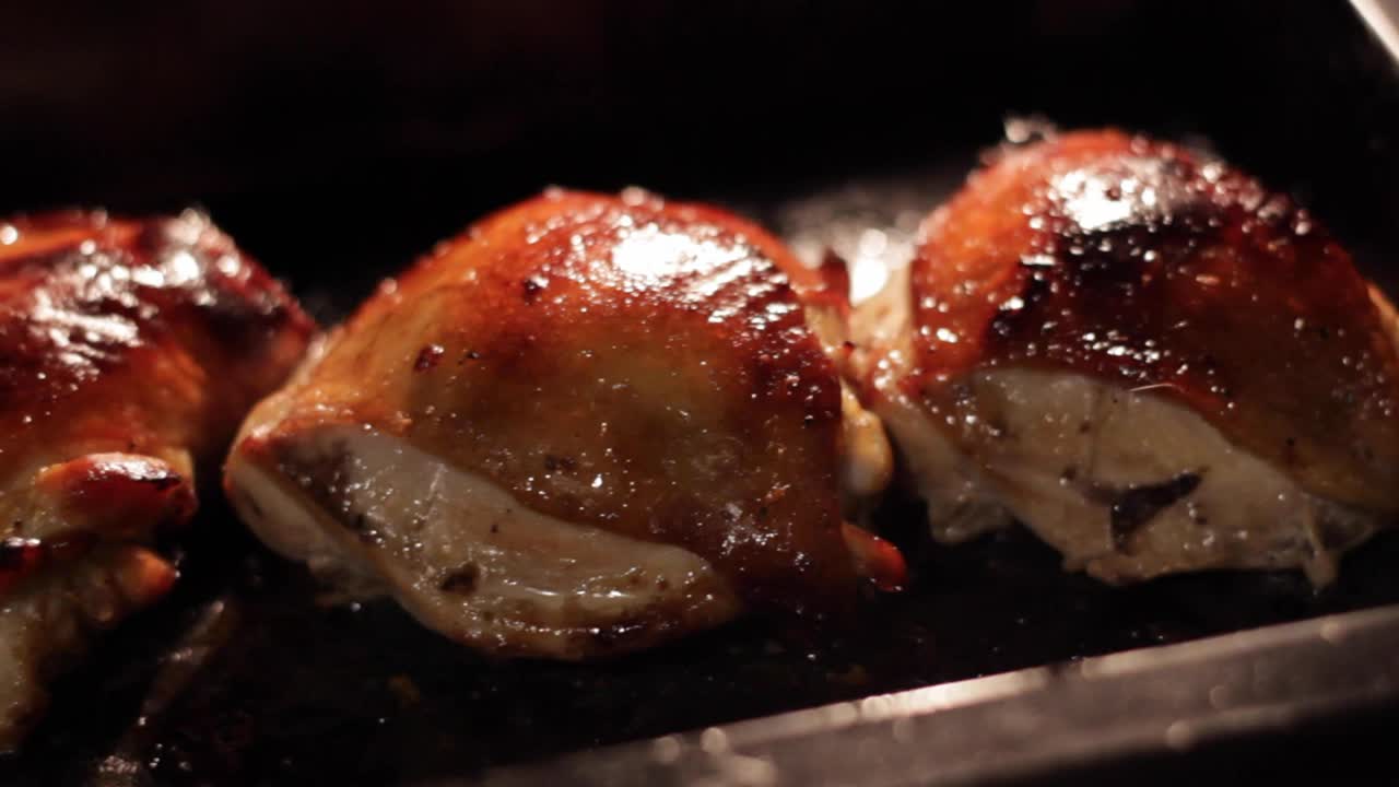 Stuffed raw oily chicken in a dark grill oven, closeup