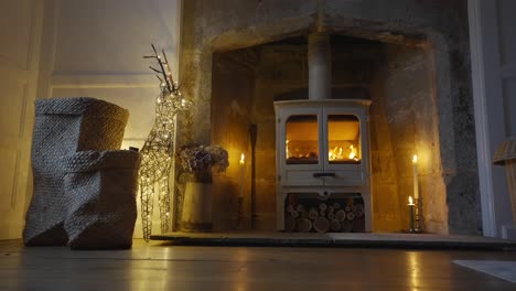 wood burning stove next to candles and christmas lights