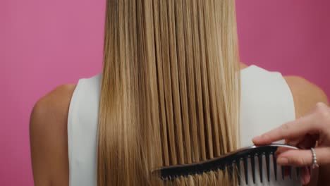 woman with long blonde hair being combed