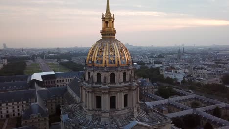 aerial orbit of les invalides golden dome at sunrise, revealing eiffel tower in the paris city in background