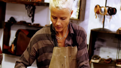 craftswoman making leather belt