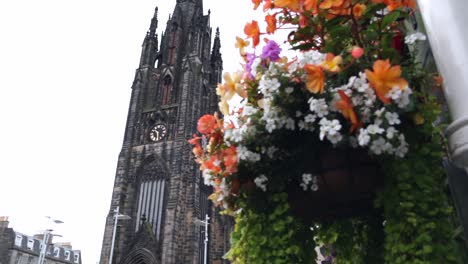 gothic cathedral being revealed behind bouquet of flowers in edinburgh, scotland panning left