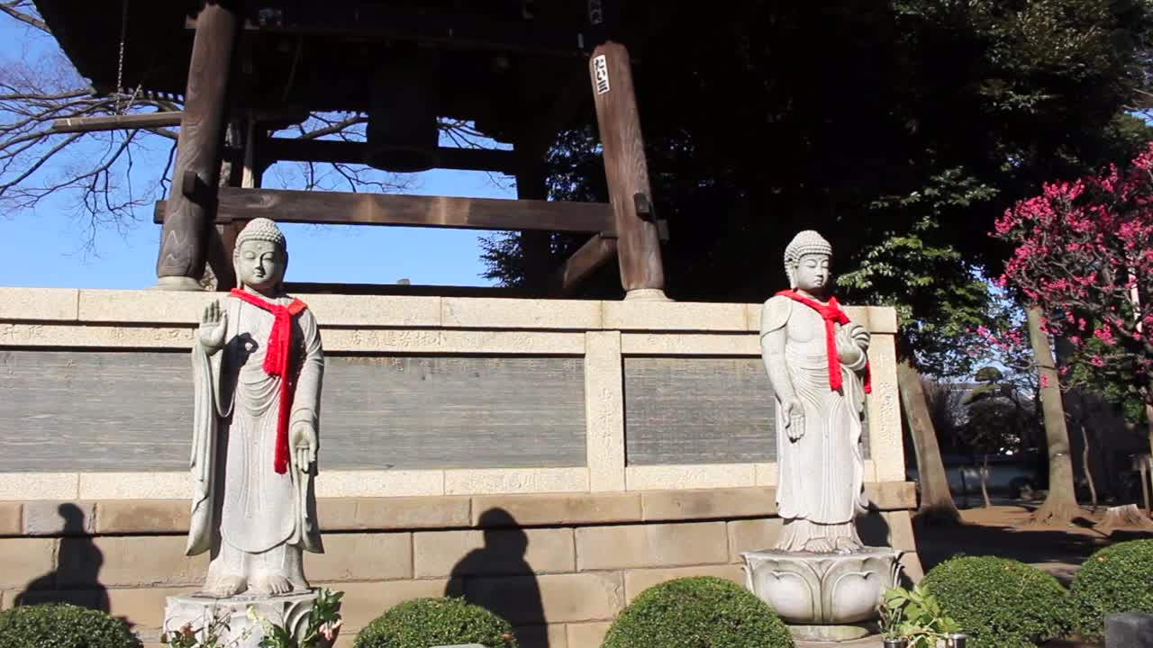 Different Buddhas with red scarves in the Tokyo temple. It is common for people to wear outfits according to the season of the year in which they are. In this case it is winter