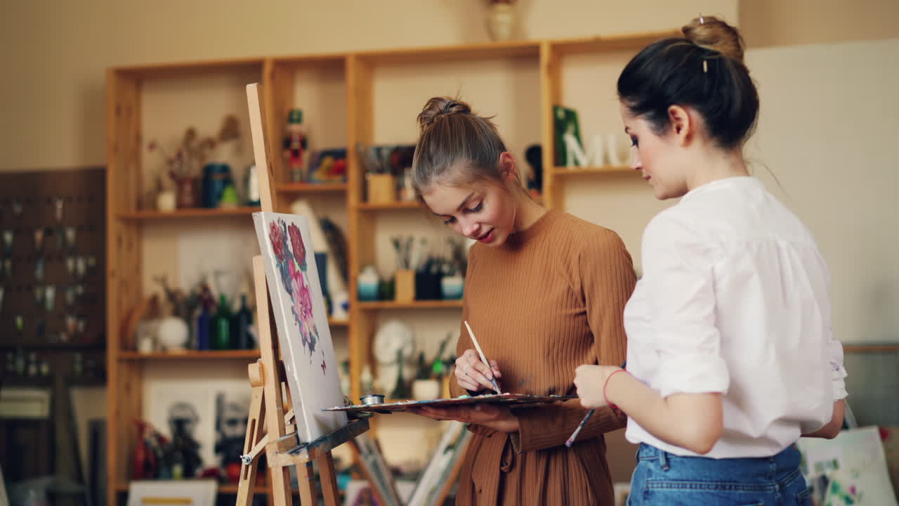 Two young women painting in an art studio