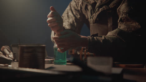 a bombmaker assembles a bomb in his workshop at night