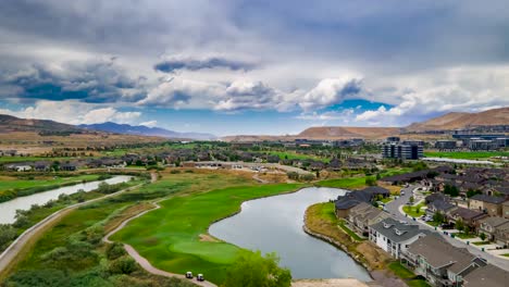 paisaje nublado dramático sobre un área suburbana y un campo de golf - hiperlapso aéreo