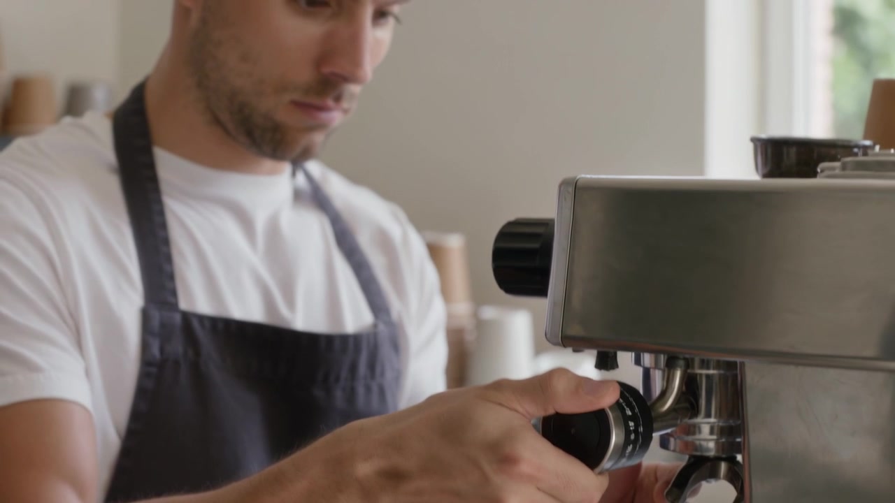 Barista white-shirt apron securing portafilter on coffee machine at cafe for brewing, copy space