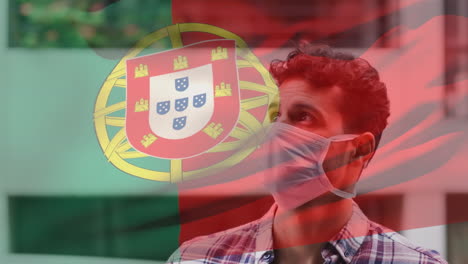 animation of flag of portugal waving over man wearing face mask during covid 19 pandemic