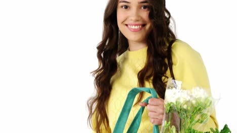 retrato de una mujer sonriente con una bolsa de comestibles