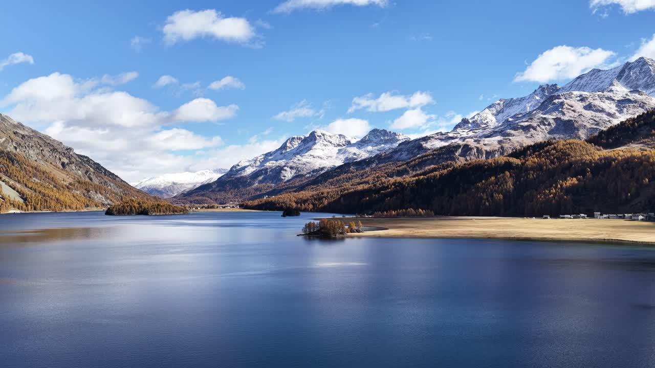 clear blue waters of lake silvaplana framed by snowy alpine peaks and autumn forests in switzerland