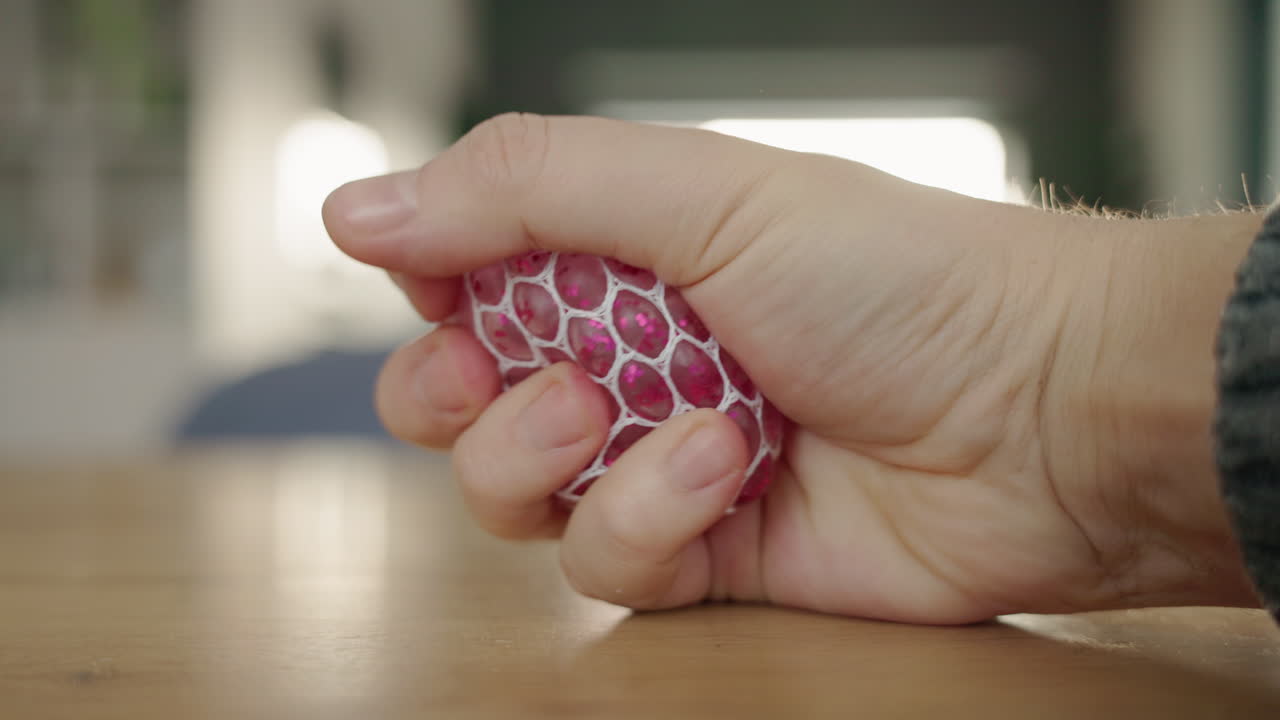 분홍색 반이는 스트레스 공을 들고 있는 사람