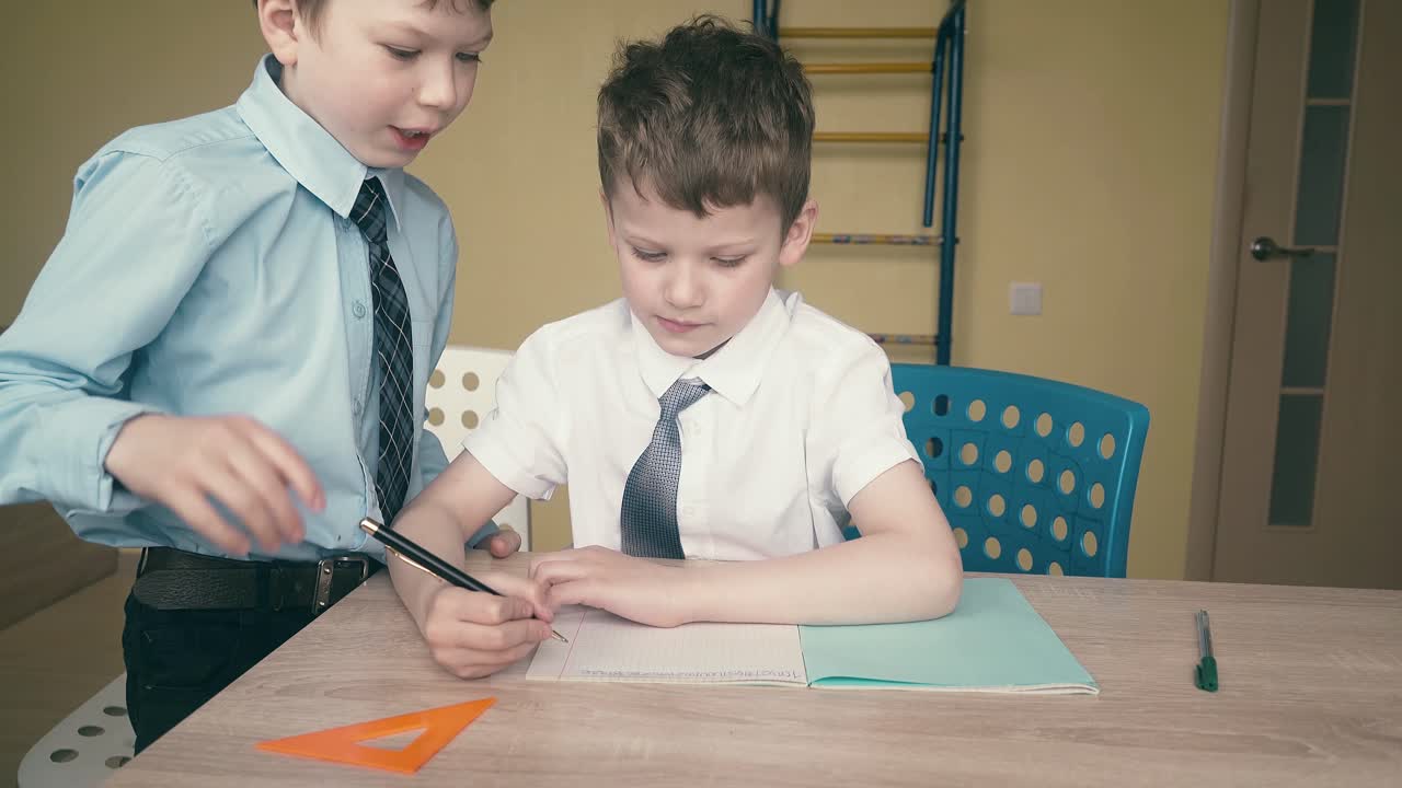 los alumnos hacen los deberes, escriben números en cuadernos, se ayudan entre sí.