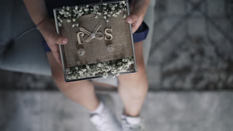 child holding wedding rings on pillow