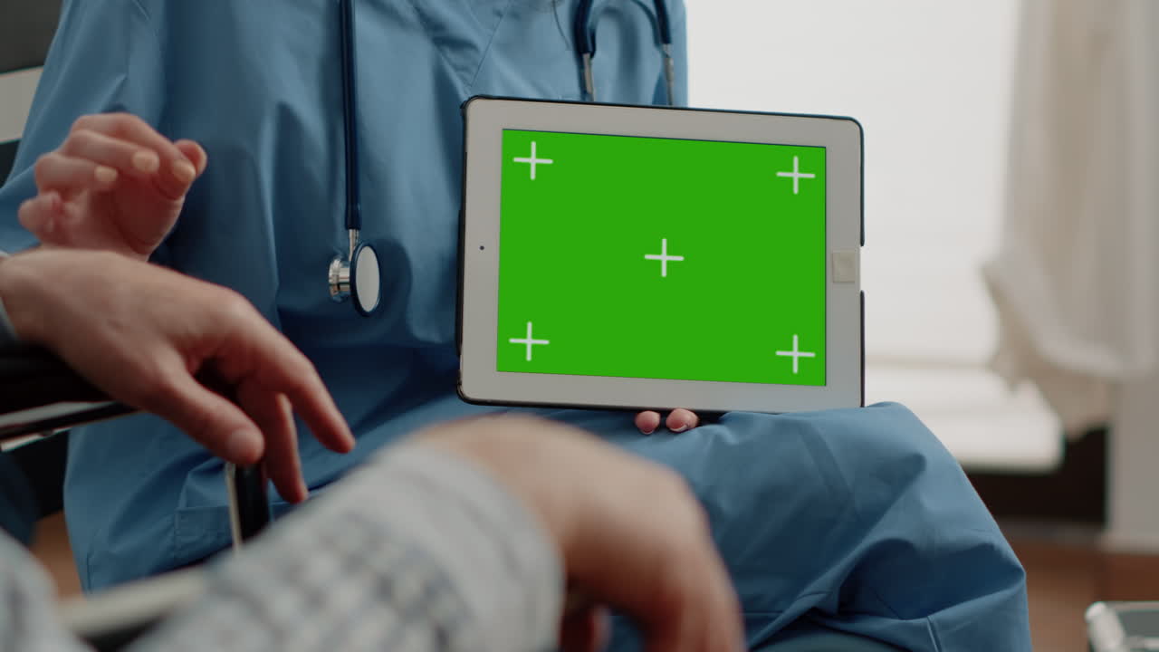 Close up of tablet with horizontal green screen in hand of nurse