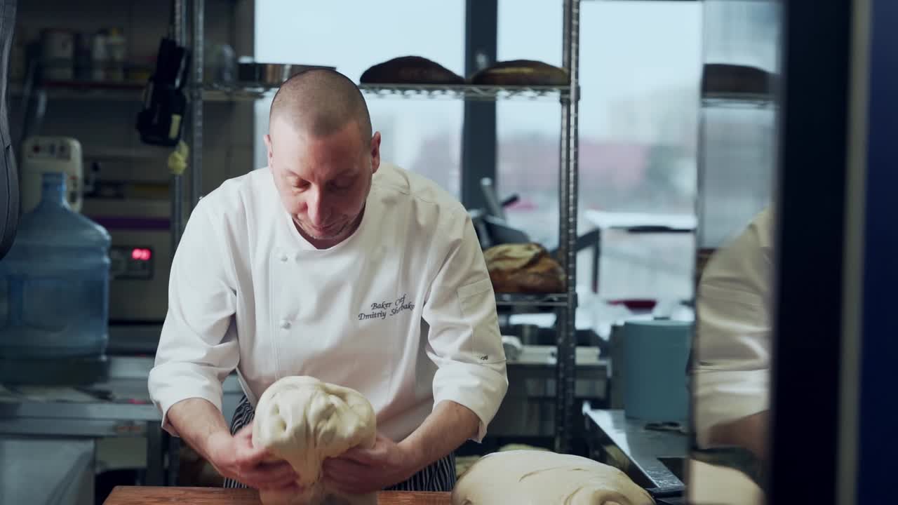 O padeiro amassa a massa de pão úmida