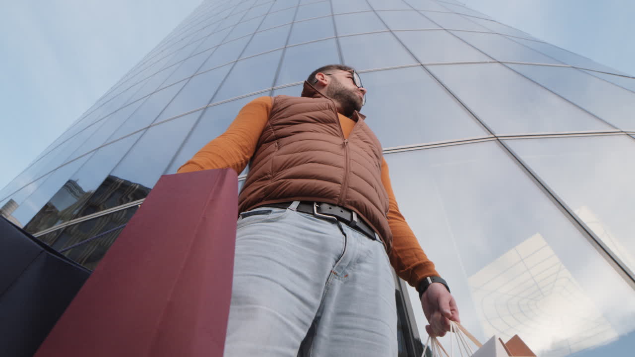 Man with Bags Walking by Building