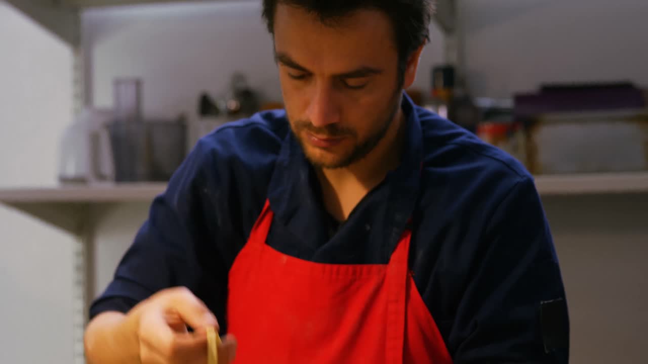 panadero masculino organizando la pasta en el estante de pasta 4k