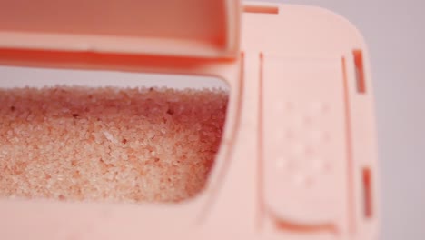 sal del himalaya rosa cruda y seca entera en un recipiente en blanco,