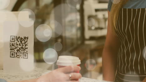 Animation-of-spots-of-light-over-woman-paying-using-smartwatch