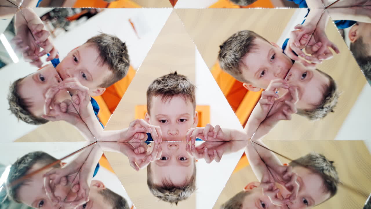 World of reflections of child. Child in a kaleidoscope tunnel. Museum of Science