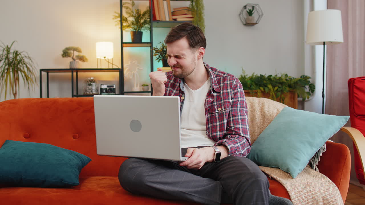 hombre molesto usando portátil teniendo ansiedad y estrés pérdida malos resultados del juego de lotería noticias en la habitación de casa