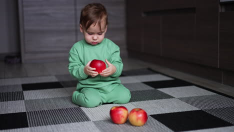baby playing with apples
