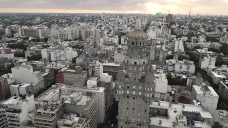 el dron gira alrededor de la cúspide del palacio salvo revelando el horizonte del paisaje urbano al atardecer de montevideo, la capital de uruguay.