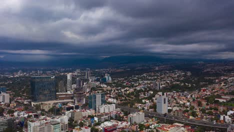 Vista-Aérea-De-Dronelapse-De-Nubes-De-Tormenta-Oscuras-Que-Se-Mueven-Sobre-Edificios-Y-Una-Carretera-Transitada,-En-La-Ciudad-De-México,-América---Retroceso,-Hiperlapso,-Disparo-De-Drones