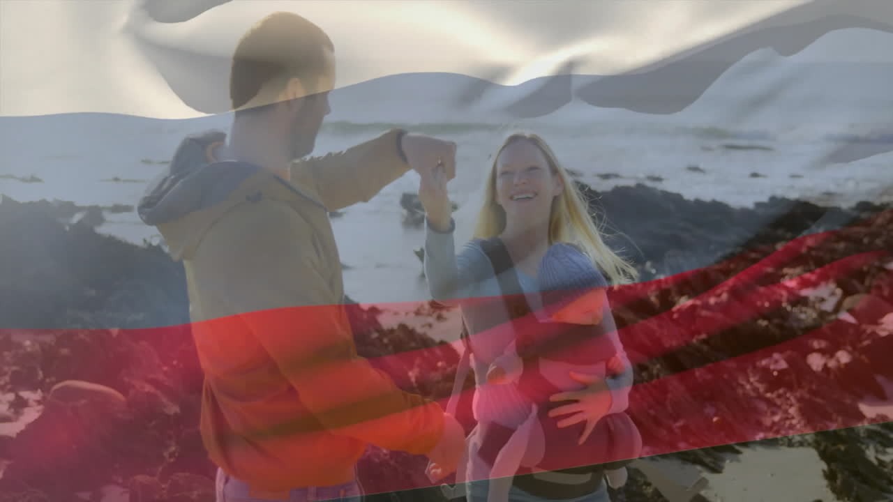 Family enjoying beach walk with baby overlaid by waving Russian flag animation