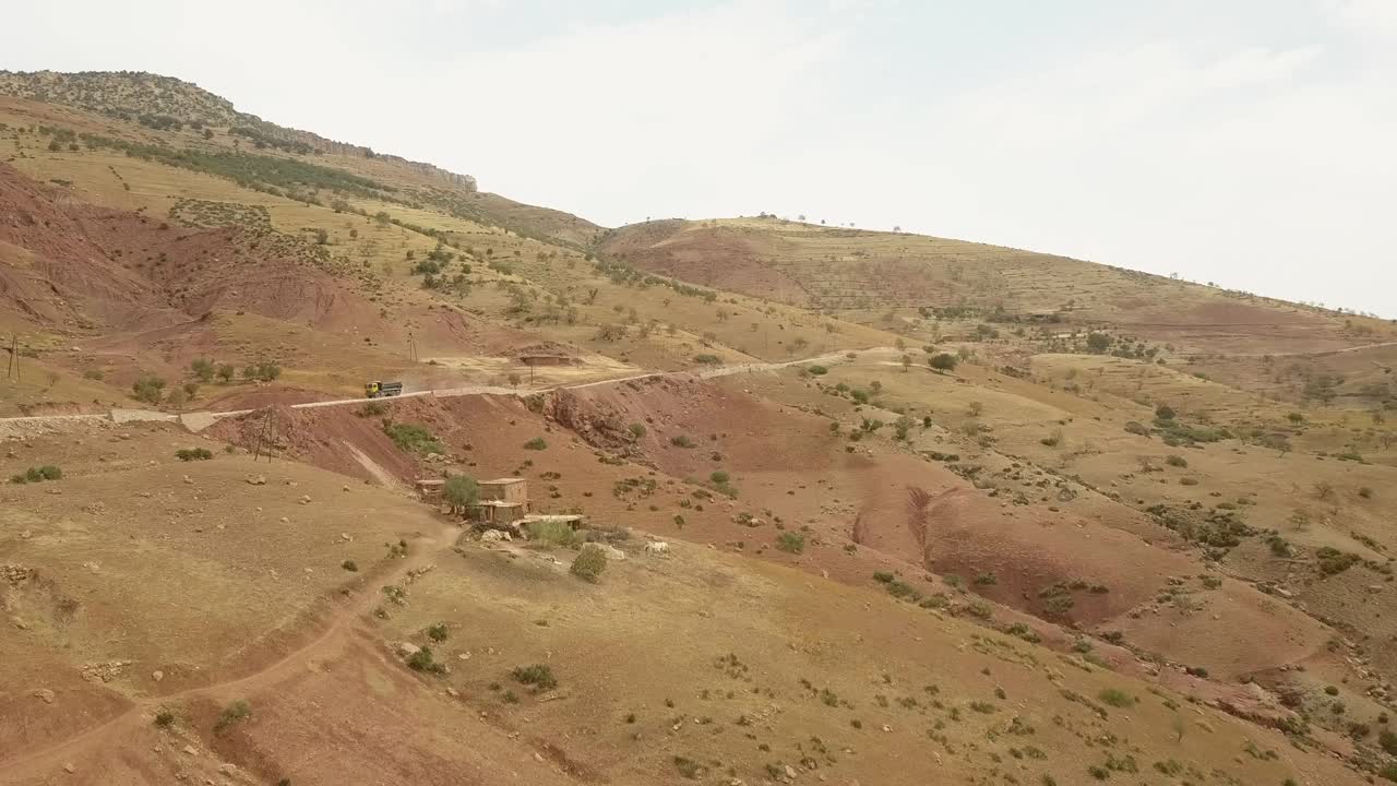 Drone view of trucks driving through the bending roads of a mountain
