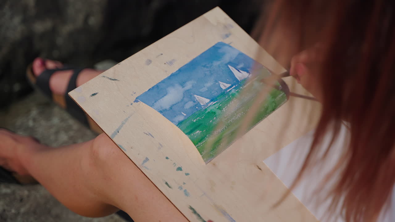 여인 이 수채화 해양 풍경 을 그린다