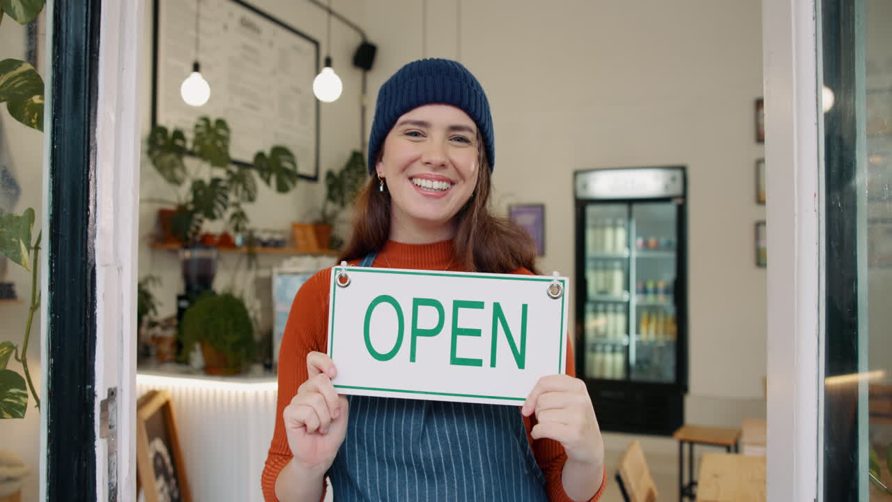 Woman holding an open sign in her shop