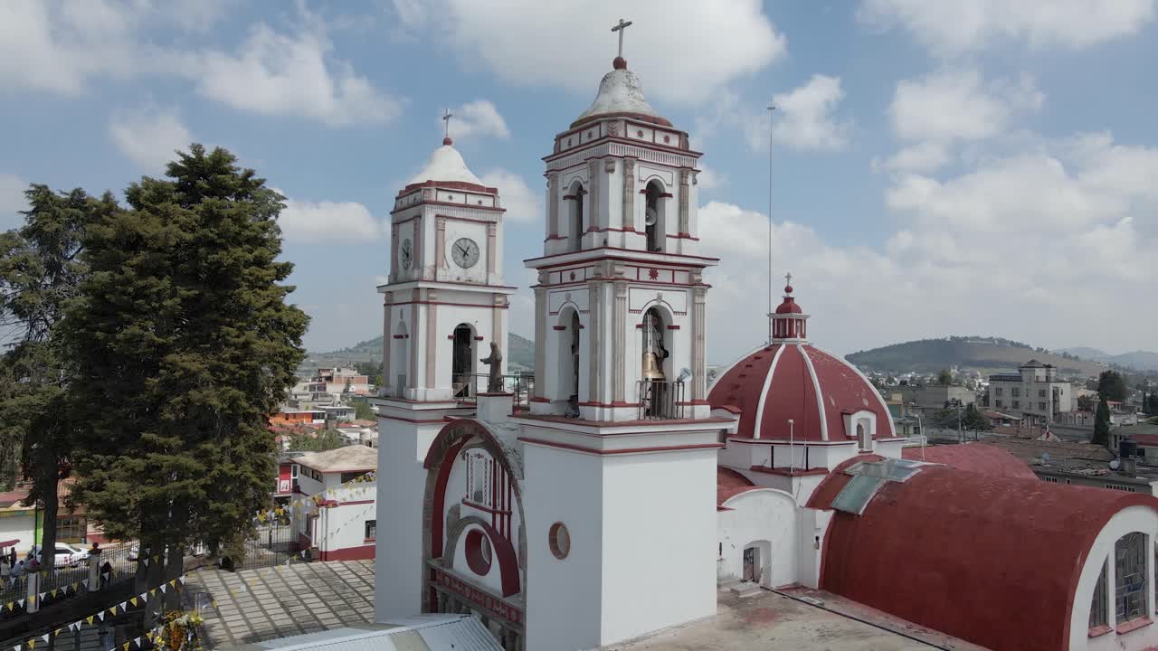 Elevated view of church with red dome and public town park with some party accessories. Drone camera flying over building in downtown. Mexico city, Mexico. some friends walking there