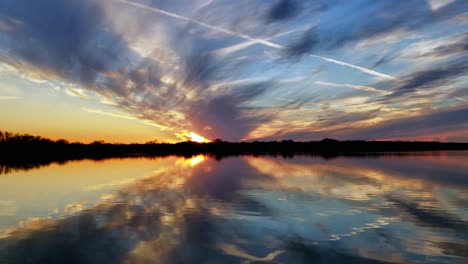 Estelas-De-Vapor-En-Texas-Time-Lapse-Puesta-De-Sol-Sobre-El-Lago-Con-Nubes-Y-Cielos-Azules