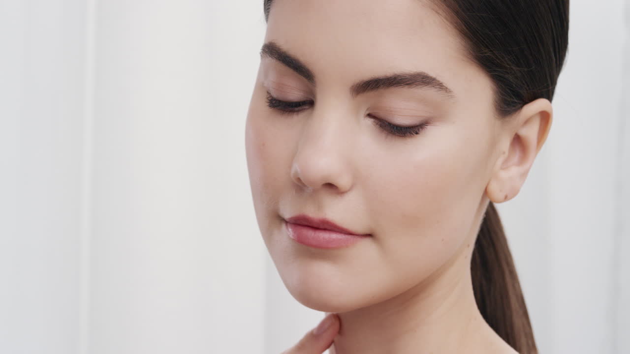 retrato de cerca de una mujer joven hermosa tocando suavemente la piel con las manos acariciando una tez suave y suave sonriendo disfrutando de una belleza natural perfecta concepto de cuidado de la piel de lujo